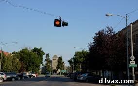 A single blinking traffic light at an intersection in a small, rural town.