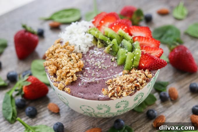 Blueberry Banana Smoothie Bowl with strawberries, kiwi, coconut, granola Delicious Blueberry Banana Smoothie Bowl topped with fresh strawberries, kiwi, shredded coconut, and granola for a vibrant, healthy breakfast.