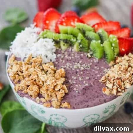 Blueberry Banana Smoothie Bowl with strawberries, kiwi, coconut, granola, and hemp seeds