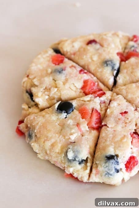 Mixed Berry Scones Before Baking Mixed Berry Scones arranged on a parchment-lined baking sheet, ready to be baked to golden perfection.