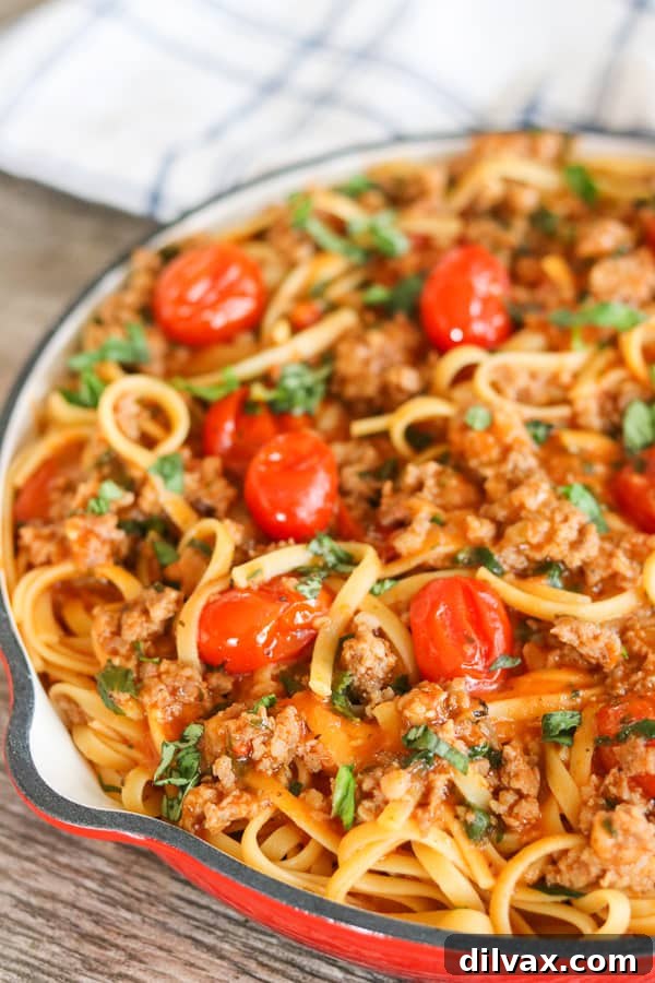 Hearty One Pot Sausage Linguine 2 A vibrant aerial shot of One-Pot Sausage Linguine showcasing the colorful blend of pasta, tomatoes, sweet Italian sausage, and herbs, perfect for a 30-minute meal.