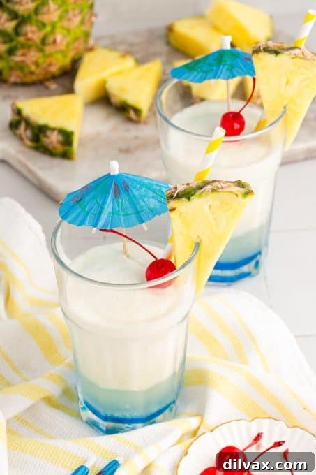 Azure Abyss Elixir 7 A stunning Caribbean-inspired Blue Ocean drink with pineapple and cherry garnishes