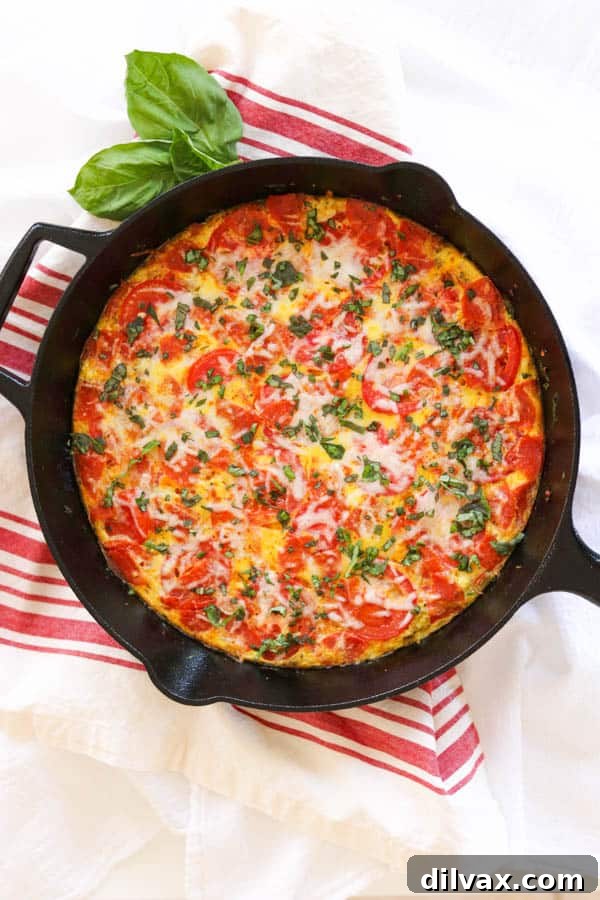 Meat Lover's Pizza Frittata in a skillet. A close-up of the Meat Lover's Pizza Frittata in a cast iron skillet, showing the perfectly cooked eggs and melted toppings.