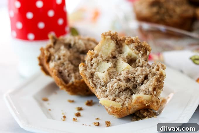 An open Apple Streusel Muffin. An open Apple Streusel Muffin revealing its tender, apple-filled interior and crumbly topping.