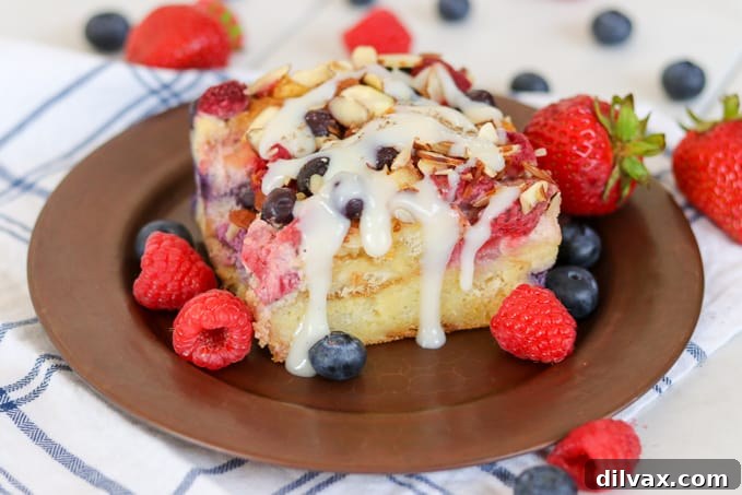 Delicious Almond Berry French Toast Casserole drizzled generously with a rich waffle sauce, ready to be served for breakfast or brunch.