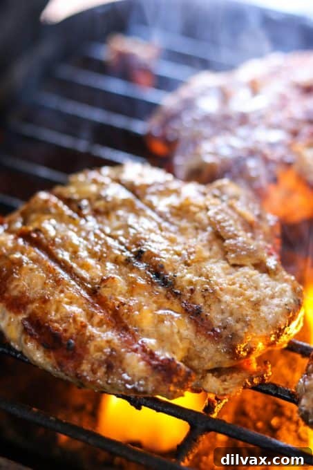 Grilling those delicious Cheesy Spiced Pork Burgers on an outdoor grill.