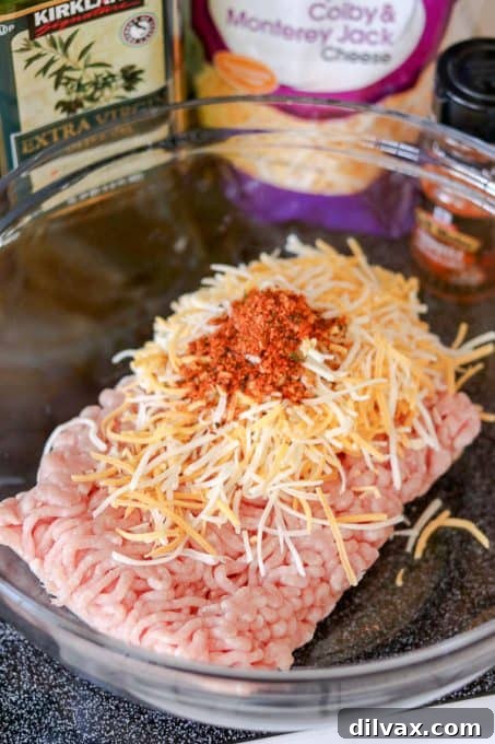 Chipotle seasoning, shredded cheddar cheeses and ground pork are the simple, yet essential ingredients for this super easy Cheesy Spiced Pork Burgers recipe.