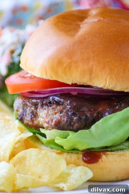 A close-up of a Cheesy Spiced Pork Burger on a bun.