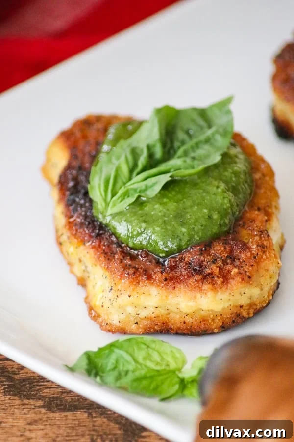A Golden Retriever puppy, Logan, sniffing at the Parmesan Pork Chops with Pesto on a plate, curious about the delicious aroma.