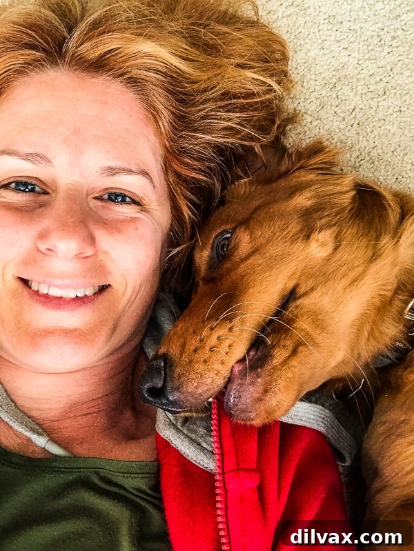 Lynne Feifer snuggling affectionately with Logan the Golden Dog, sharing a peaceful moment together.