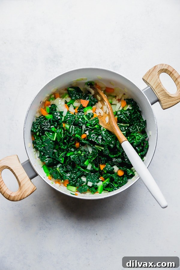 Vegetable sautéing for One Pot Bacon and Tortellini Zuppa Toscana. Fresh vegetables, including carrots, celery, and onions, sautéing in a pan for the soup.