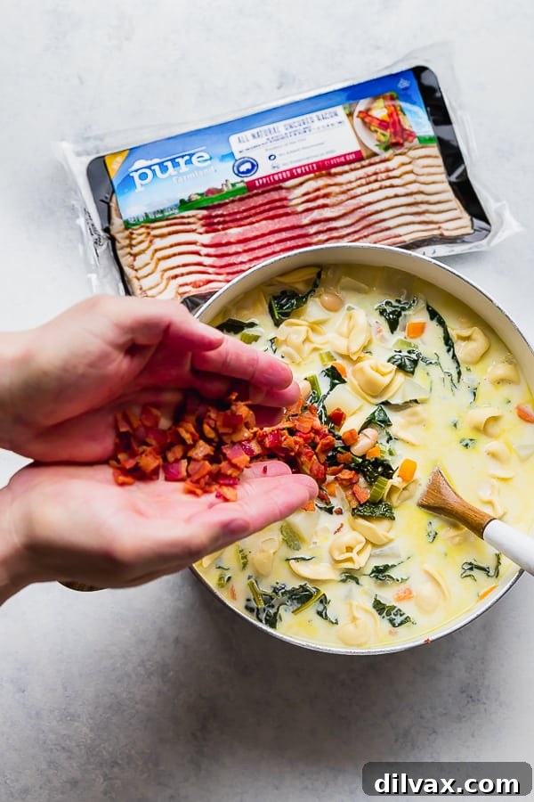 Adding Pure Farmland Bacon to One Pot Bacon and Tortellini Zuppa Toscana. Adding crispy Pure Farmland Bacon pieces back into the One Pot Bacon and Tortellini Zuppa Toscana.