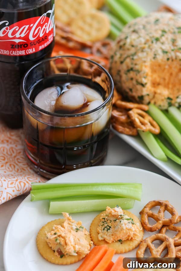 A vibrant piece of Buffalo Chicken Cheese Ball on a cracker, showcasing its creamy interior and flavorful ingredients.