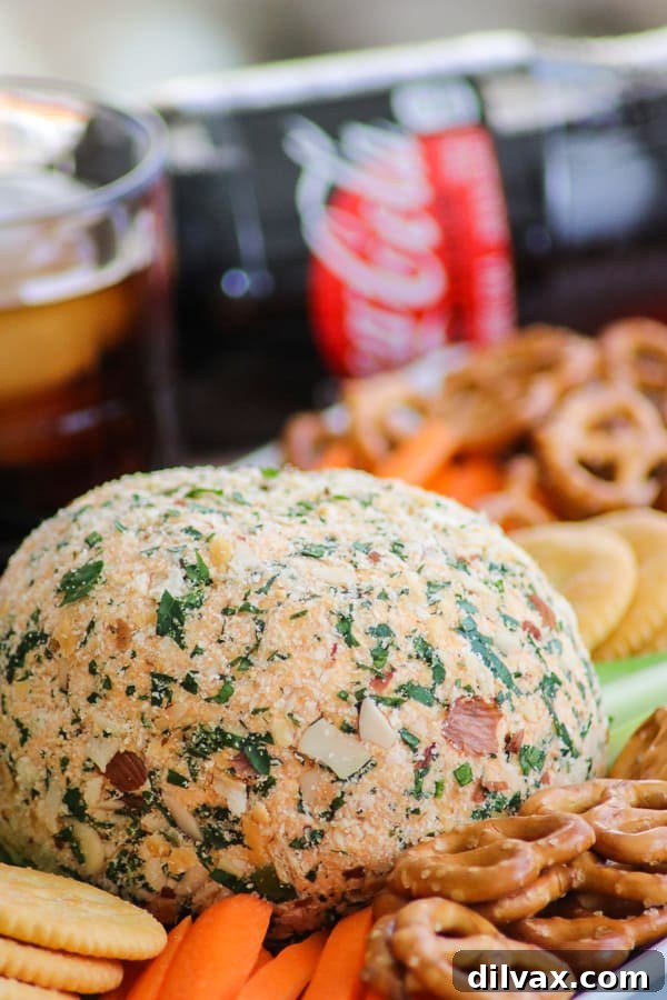 A final, mouth-watering shot of the Buffalo Chicken Cheese Ball, with a chilled Coca-Cola Zero Sugar bottle in the background, completing a perfect snack arrangement.