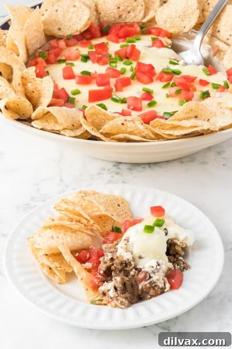 A cheesy dip made with taco seasoned ground beef and refried beans.