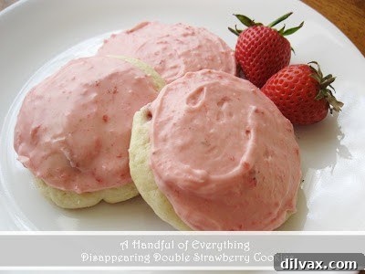 Platter of iced strawberry cookies with fresh strawberries