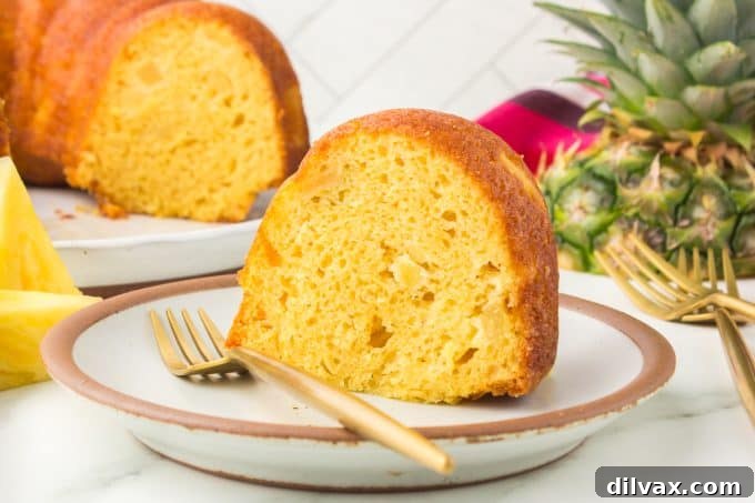 A beautifully glazed Pineapple Rum Cake in a bundt pan, ready to be sliced.