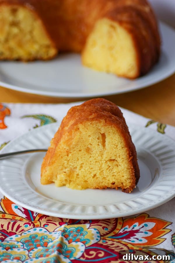 A perfect slice of Pineapple Rum Cake presented on a plate with a fork, tempting and delicious.