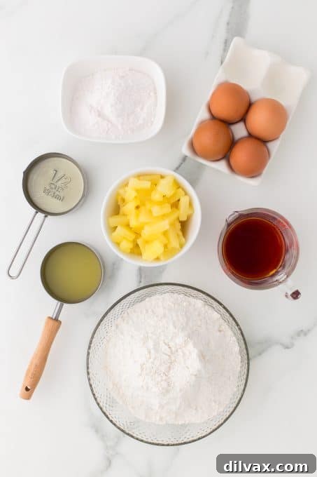A collection of ingredients laid out, including pineapple, eggs, rum, and cake mix for Pineapple Rum Cake.
