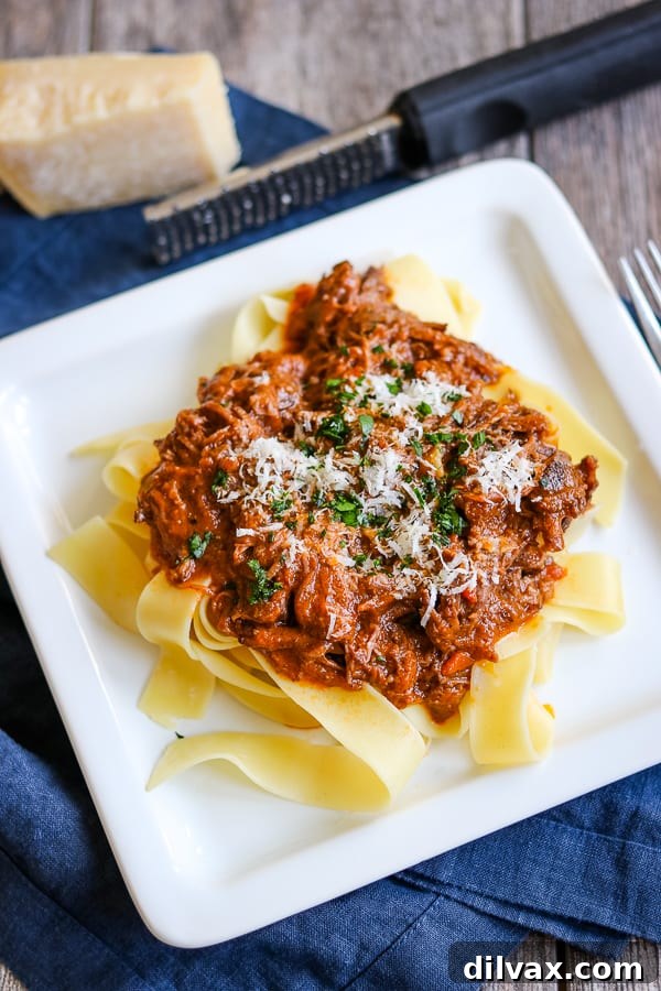 A close-up of a plate of Braised Short Ribs, tender and glistening with sauce.