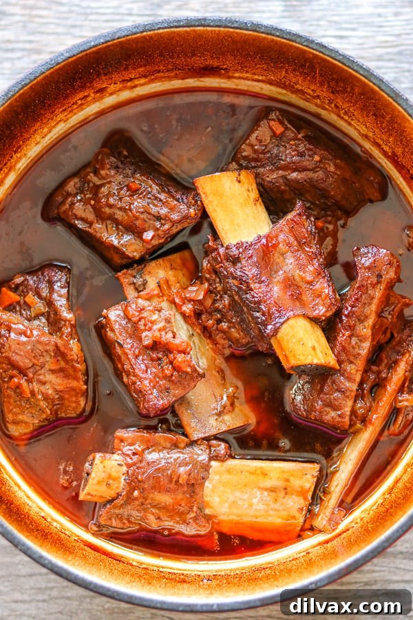 Braised short ribs simmering in a large pot, rich with sauce.