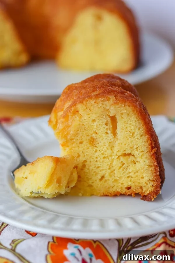 A bite of Pineapple Rum Cake on a fork. A delicious bite of Pineapple Rum Cake delicately balanced on a fork, ready to be enjoyed.