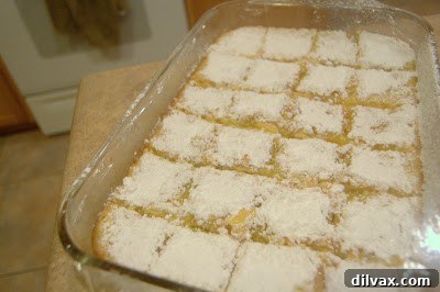 A freshly baked pan of lemon squares, ready for dusting.