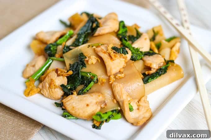 A Thai recipe, Pad See Ew, served with chicken and broad rice noodles.