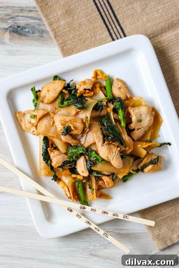 A plate of Pad See Ew with chopsticks ready to enjoy.