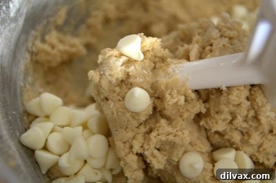 Rounded tablespoonfuls of cookie dough neatly arranged on a parchment-lined baking sheet, ready for the oven.