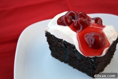 Lush Cherry Topped Chocolate Poke Cake with whipped cream and cherries