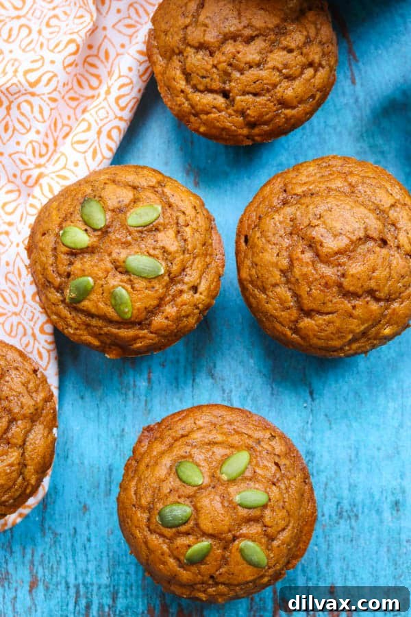 A selection of Dairy-Free Pumpkin Muffins, some topped with pepitas, others plain.