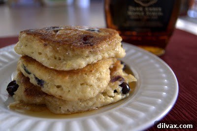 Freshly cooked pancakes stacked high with syrup