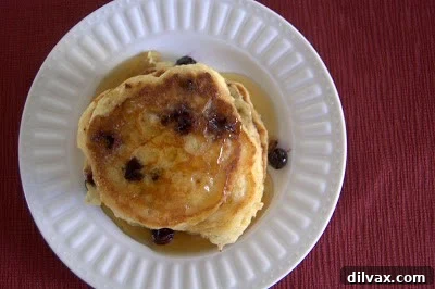 Another angle of stacked pancakes with syrup and blueberries