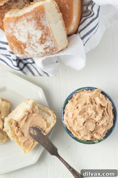 Whipped Cinnamon Honey Butter 8 Spreading butter with honey and cinnamon on a dinner roll.