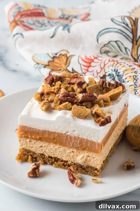 Creamy Pumpkin Dream 9 A close-up of a slice of pumpkin lush, highlighting the distinct layers of creamy pumpkin cheesecake, pudding, and whipped topping.