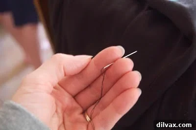 Step 1: Threaded needle held by fingers, showing thread ends.