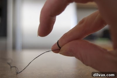 Step 3: Sliding the thread loops off the finger.