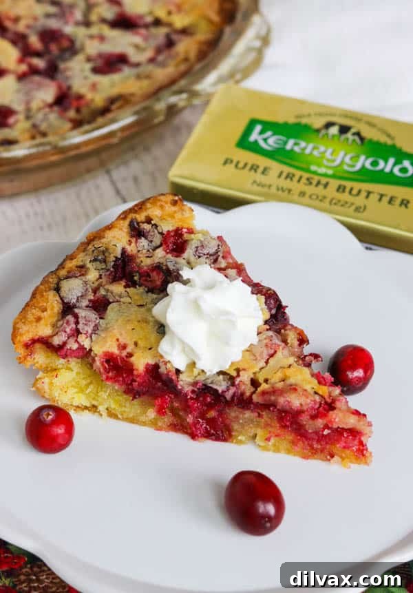 A beautifully presented slice of Easy Cranberry Pie Recipe, garnished with whipped cream, on a small pie plate, ready to be served.