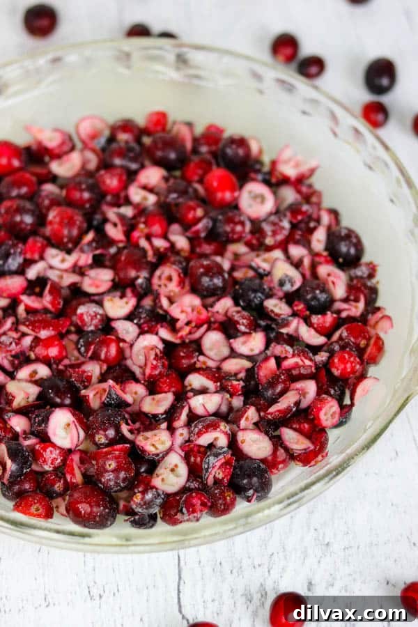 A bowl of fresh cranberries, some whole and some roughly chopped, prepared for the Easy Cranberry Pie Recipe.
