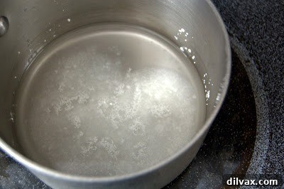 The Secret Recipe for Turkish Delight Revealed 4 Sugar dissolving in water in a small saucepan on a stovetop.