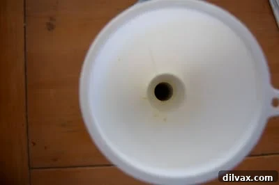 Pouring homemade creamer into a jar using a funnel