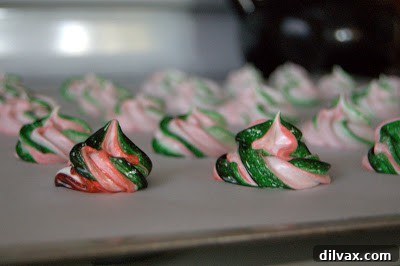 Three egg whites in a stand mixer bowl, just starting to become frothy.