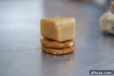 Caramel placed on top of a peanut butter pretzel sandwich.