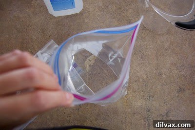 A Ziploc bag containing water and rubbing alcohol, clearly showing the liquid mixture ready for sealing.