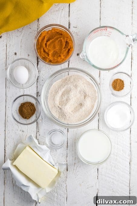 Hearty Pumpkin Wheat Stack 4 Arrangement of fresh ingredients for whole wheat pumpkin pancakes, including flour, sugar, spices, pumpkin puree, eggs, and milk.