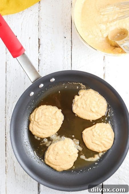 Hearty Pumpkin Wheat Stack 6 Golden-brown pumpkin pancakes cooking on a griddle, showing the perfect sizzle.