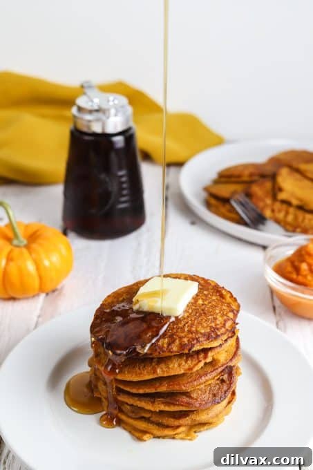 Hearty Pumpkin Wheat Stack 8 A stack of golden whole wheat pumpkin pancakes, ready to be served.