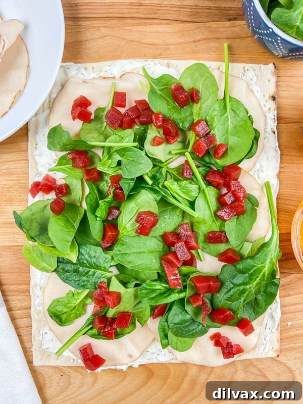 The delicious layers of beets, fresh spinach, and savory turkey assembled for a Beet, Turkey, and Cheese Wrap.