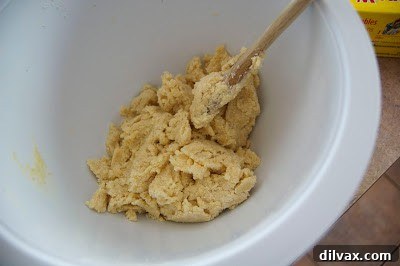 Buttermilk carefully poured into the galette dough mixture, which is now starting to coalesce and stick together.